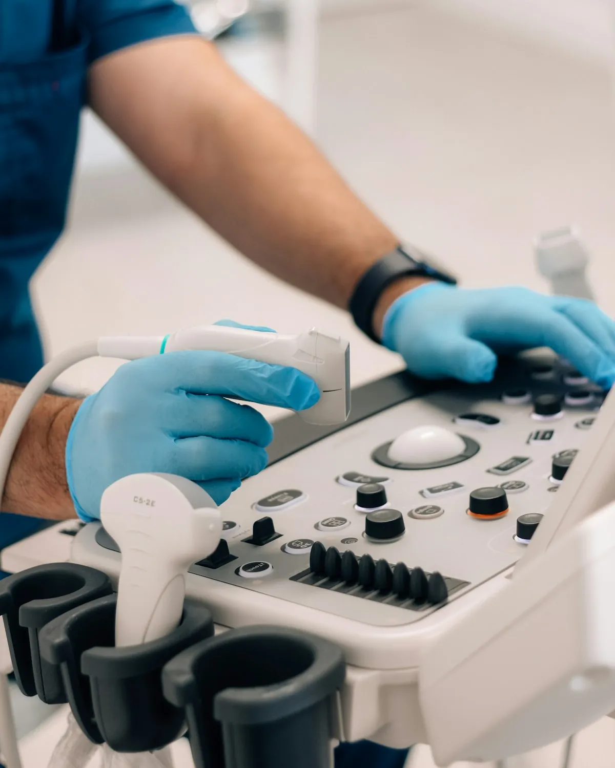 Mâini cu mănuși medicale la un aparat din cabinet